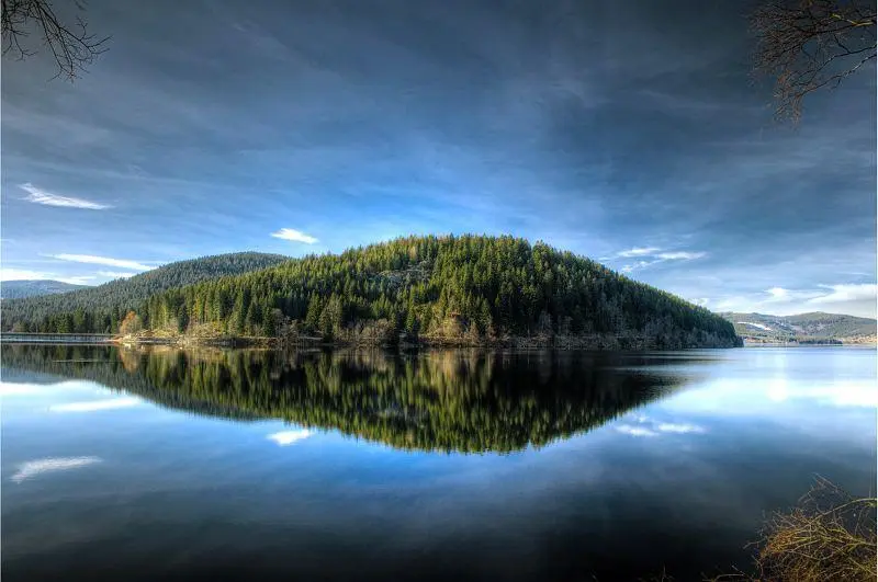 Panorama des Schluchsees mit Booten am Steg und den Tannenhängen des Schwarzwalds