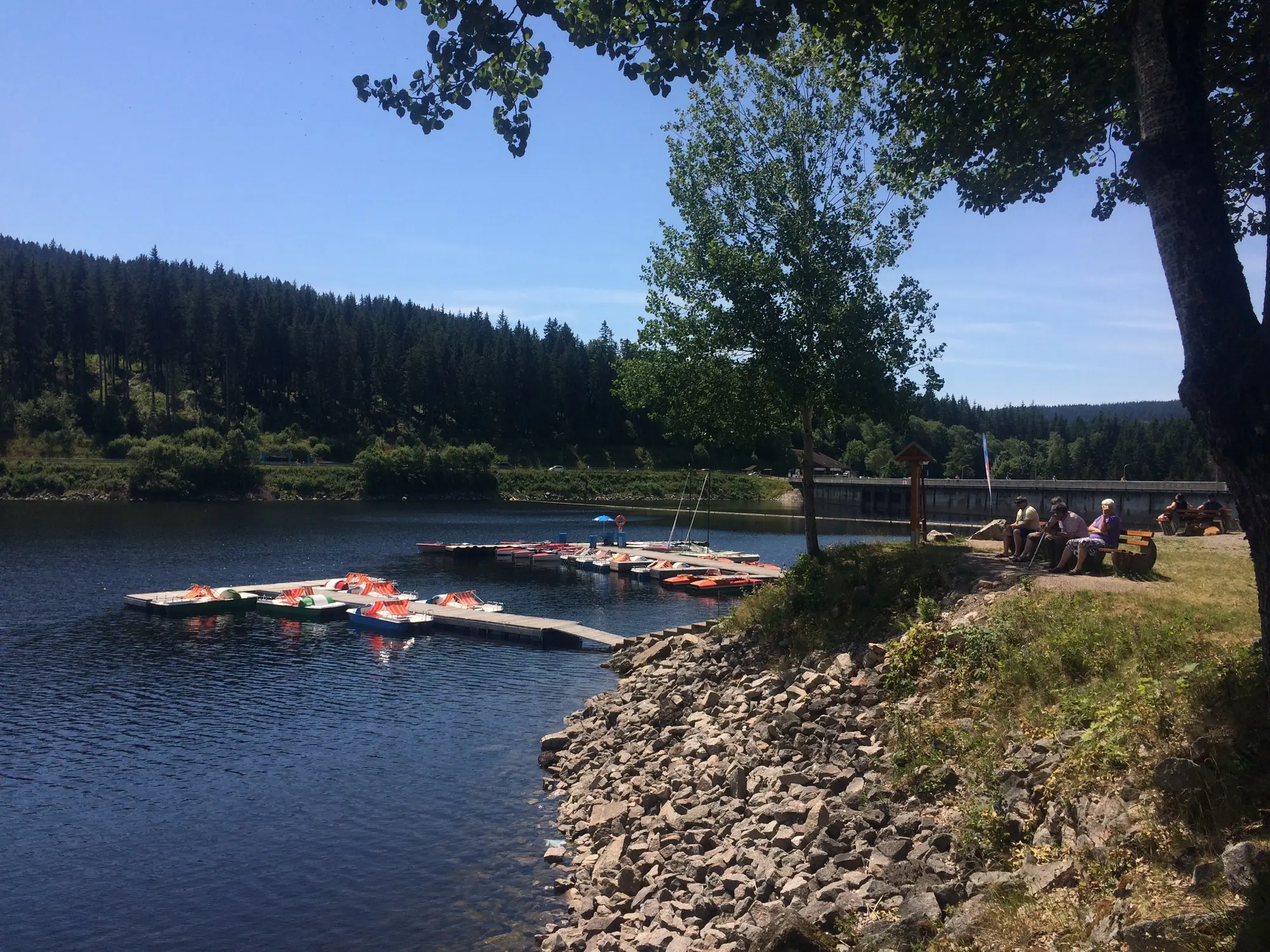 Bootssteg an der Staumauer mit Tretbooten, Felsufer und Sitzbänken am Schluchsee